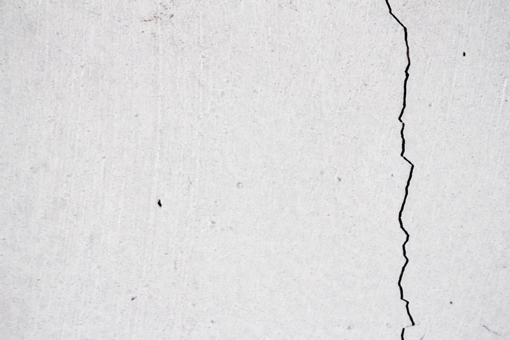 A stark crack disrupts the smooth, white surface, hinting at hidden fractures beneath.