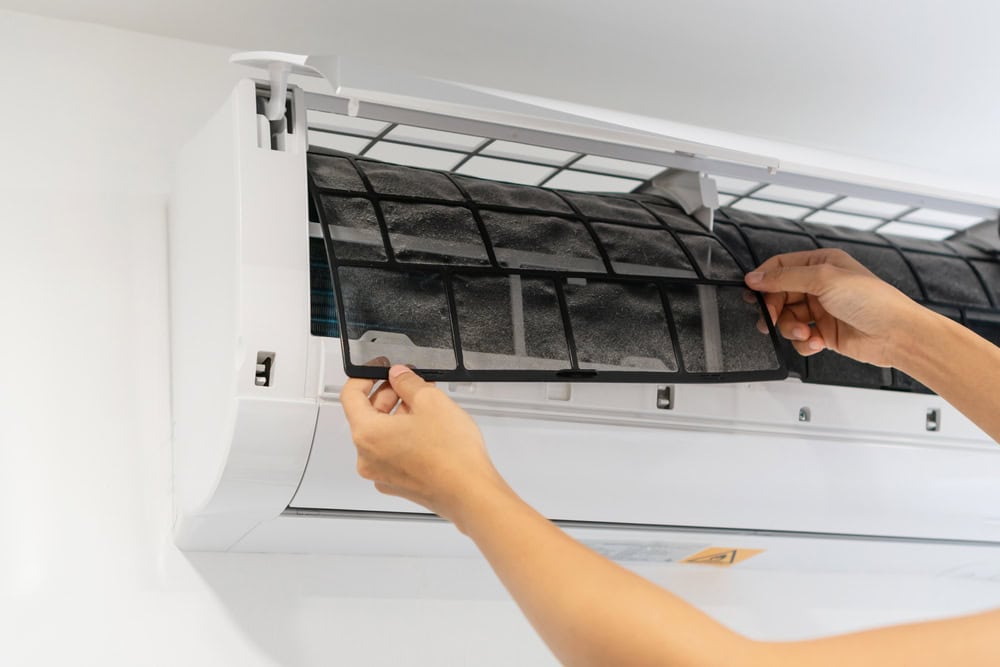 Cleaning the air conditioner filter for better air quality and efficiency.