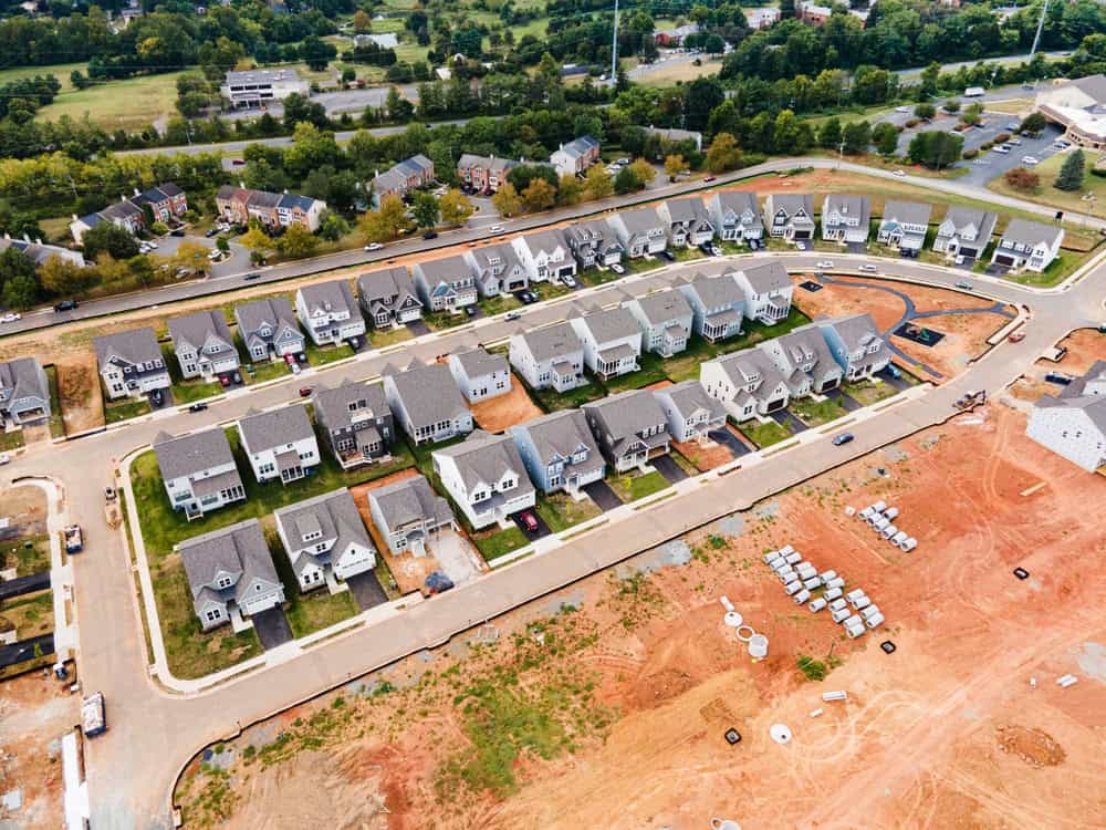 A growing suburban neighborhood: modern homes, neatly lined streets, and new developments on the horizon.