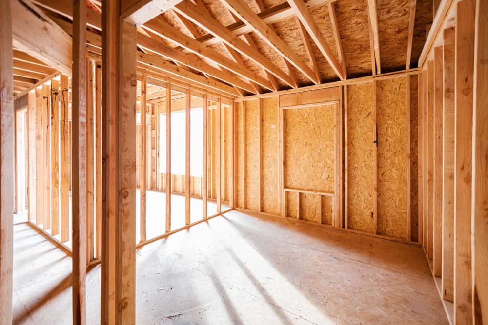 A bright, open space in the midst of construction, with wooden beams and framing ready for transformation.