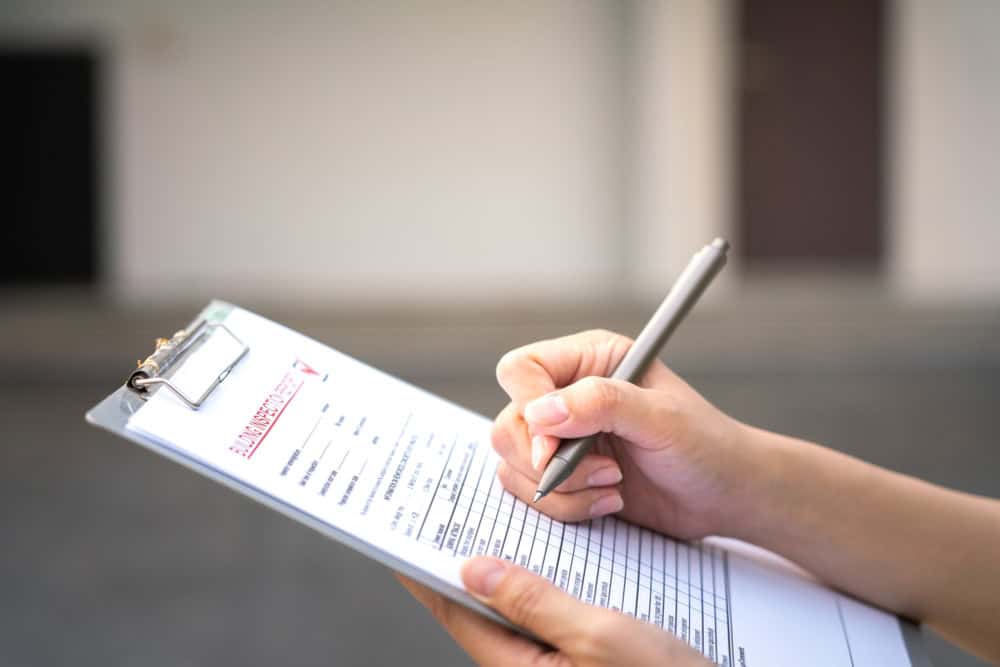 Filling out a building inspection report with precision.