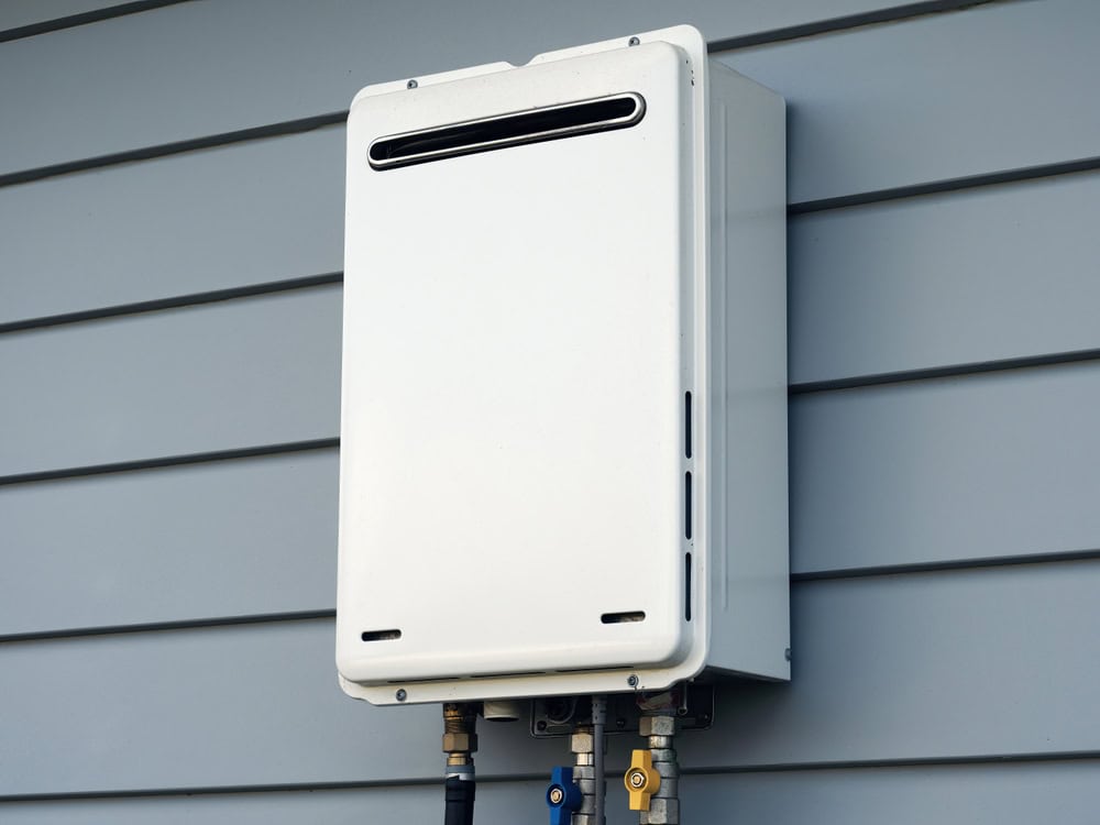 Energy-efficient tankless water heater mounted on an exterior wall.