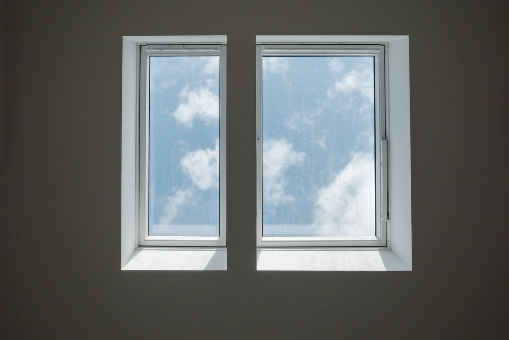 Two windows framing a serene view of the sky and clouds, bringing the outdoors in.