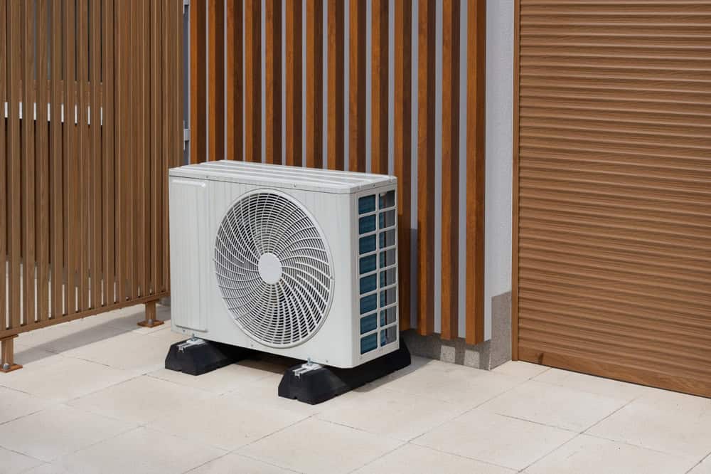 Modern outdoor air conditioning unit blending with sleek wooden paneling.