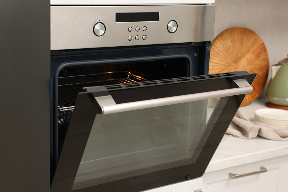 A modern kitchen oven with its door open, ready for baking in a cozy home setting.