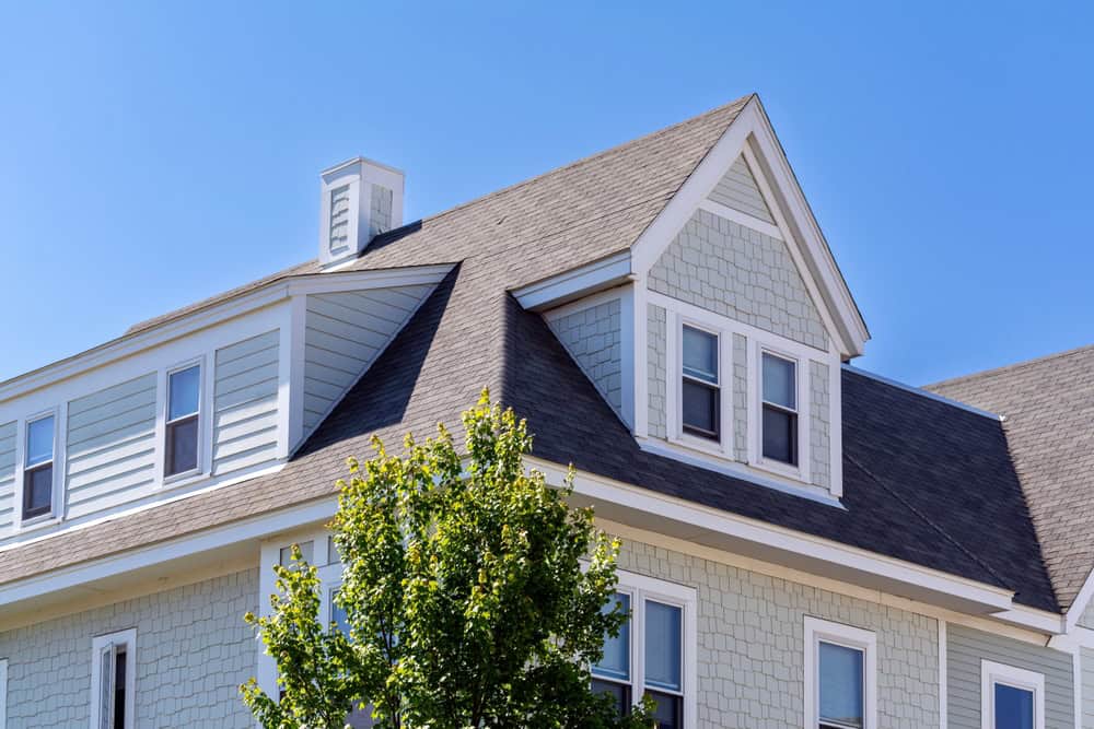 Charming modern Victorian home under a bright blue sky.