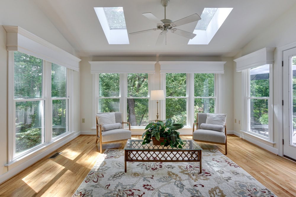 A serene sunroom retreat with natural light, cozy seating, and lush outdoor views.