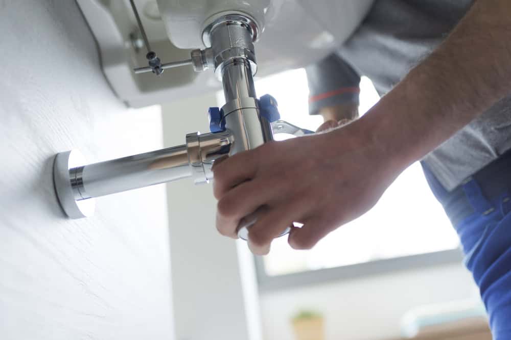 Fixing the plumbing under the sink with precision and care.