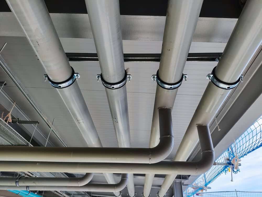 Industrial pipes suspended from the ceiling, showcasing the intricate network of a modern infrastructure.