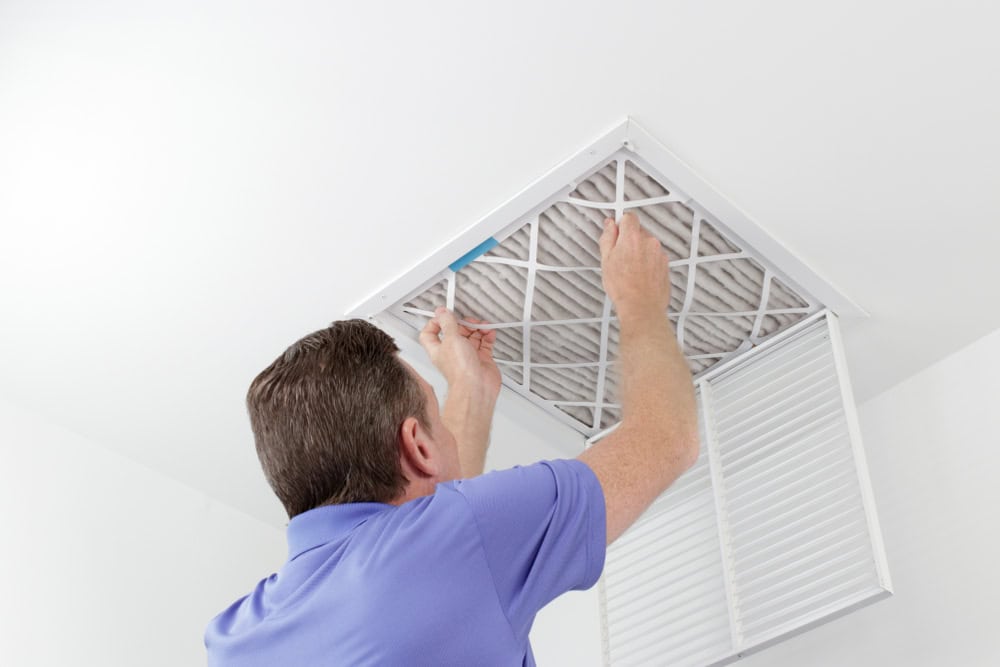 Changing the air filter for a healthier home environment.