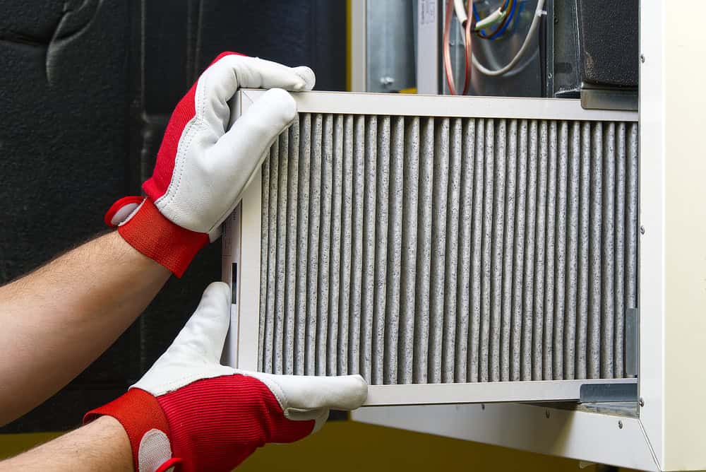 Changing the HVAC filter for better air quality and system efficiency.