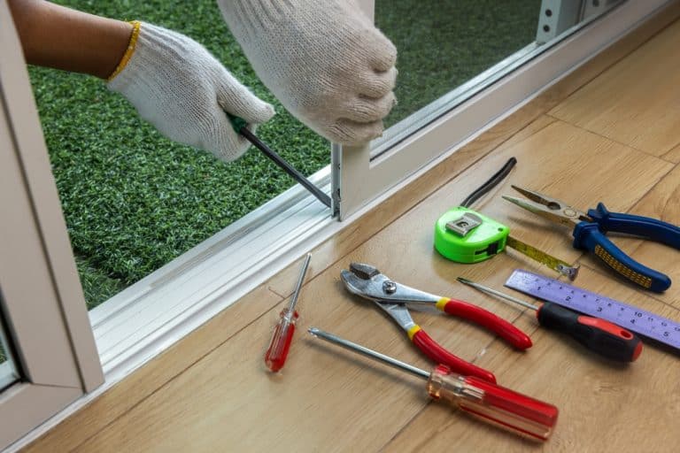 Screen door repair in progress: Tools ready, hands at work.