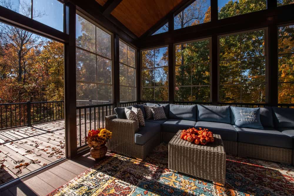 Cozy autumn afternoons in this sunlit screened-in porch, surrounded by vibrant fall foliage.