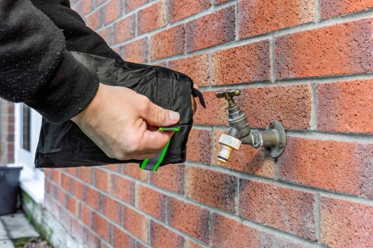 Securing the water supply with a protective cover on an outdoor tap.