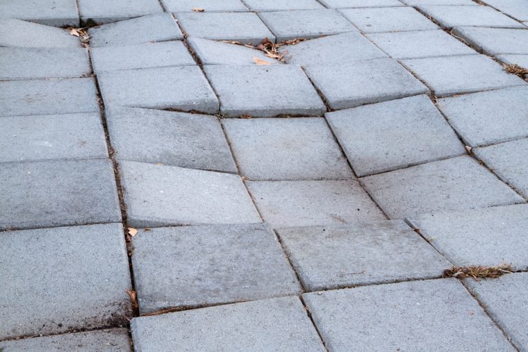 Uneven pavement tiles showing signs of wear and tear.