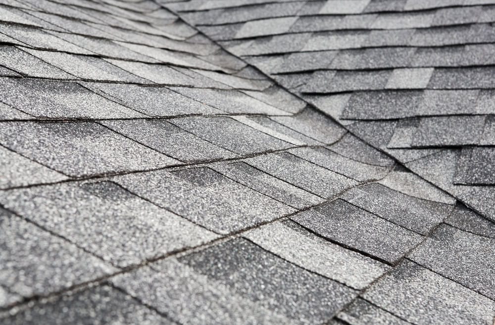 Close-up of weathered shingles on a roof, showcasing texture and age.