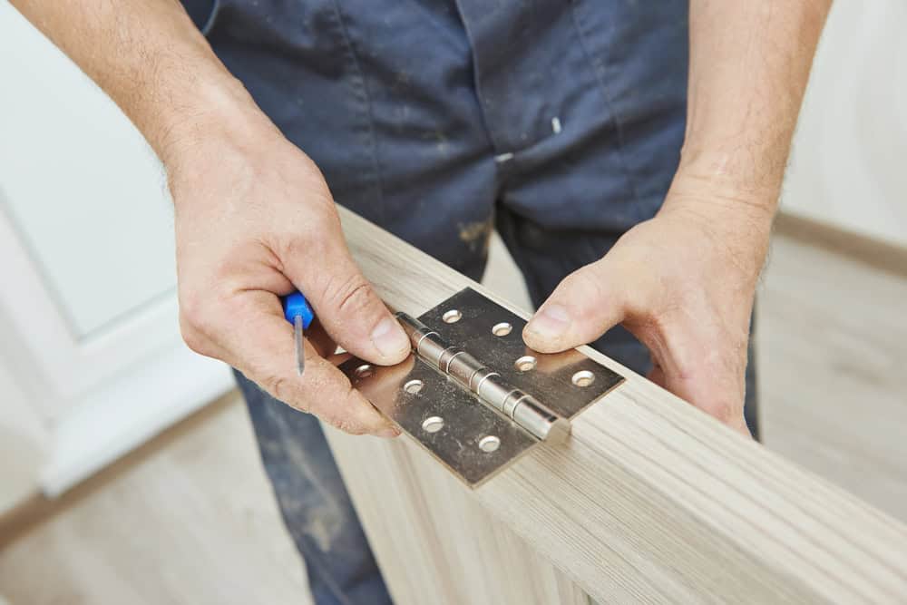 Installing a door hinge with precision and care.