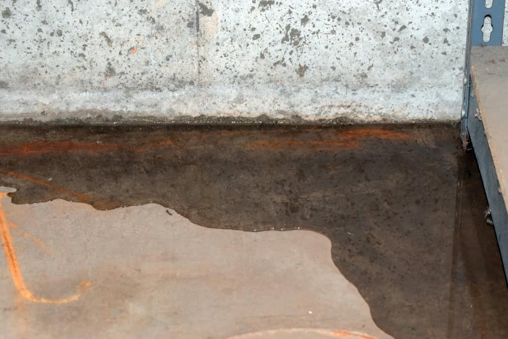 A flooded basement with water pooling on the concrete floor.