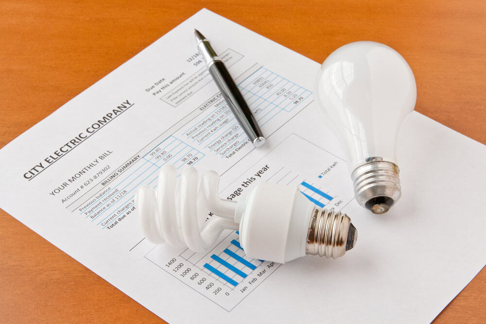 Comparing energy efficiency: traditional, CFL, and LED light bulbs on an electric bill.