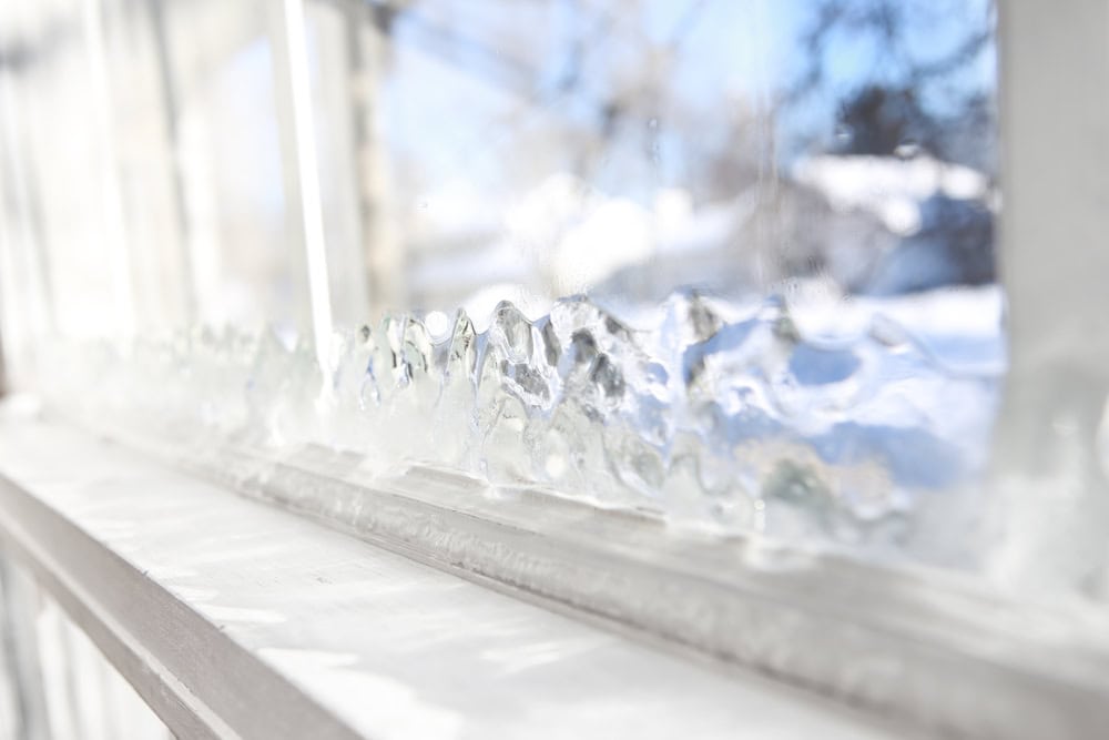 Frosty patterns adorn the window, capturing the serene beauty of winter.