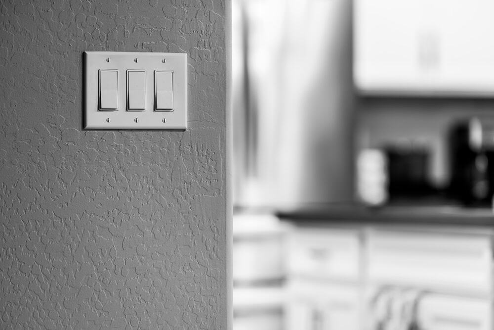 A close-up of a light switch panel on a textured wall.