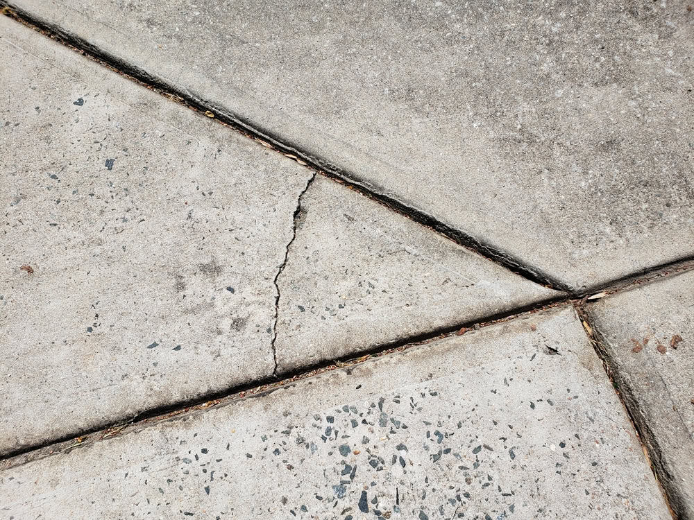 Cracked concrete: a testament to time and wear, revealing the stories etched into the pavement.