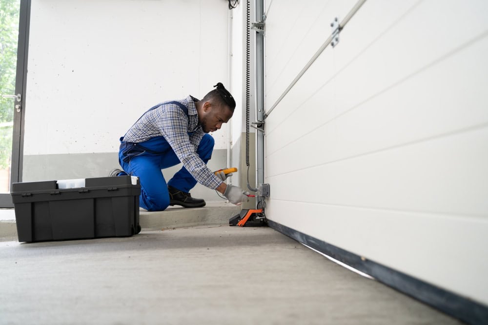 A technician meticulously repairs a garage door, ensuring everything is in perfect working order.