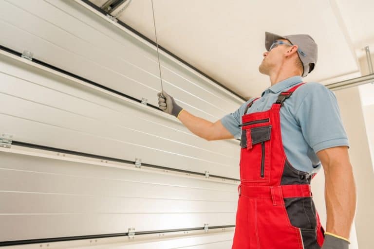 A technician inspects a modern garage door, ensuring everything is in perfect working order.