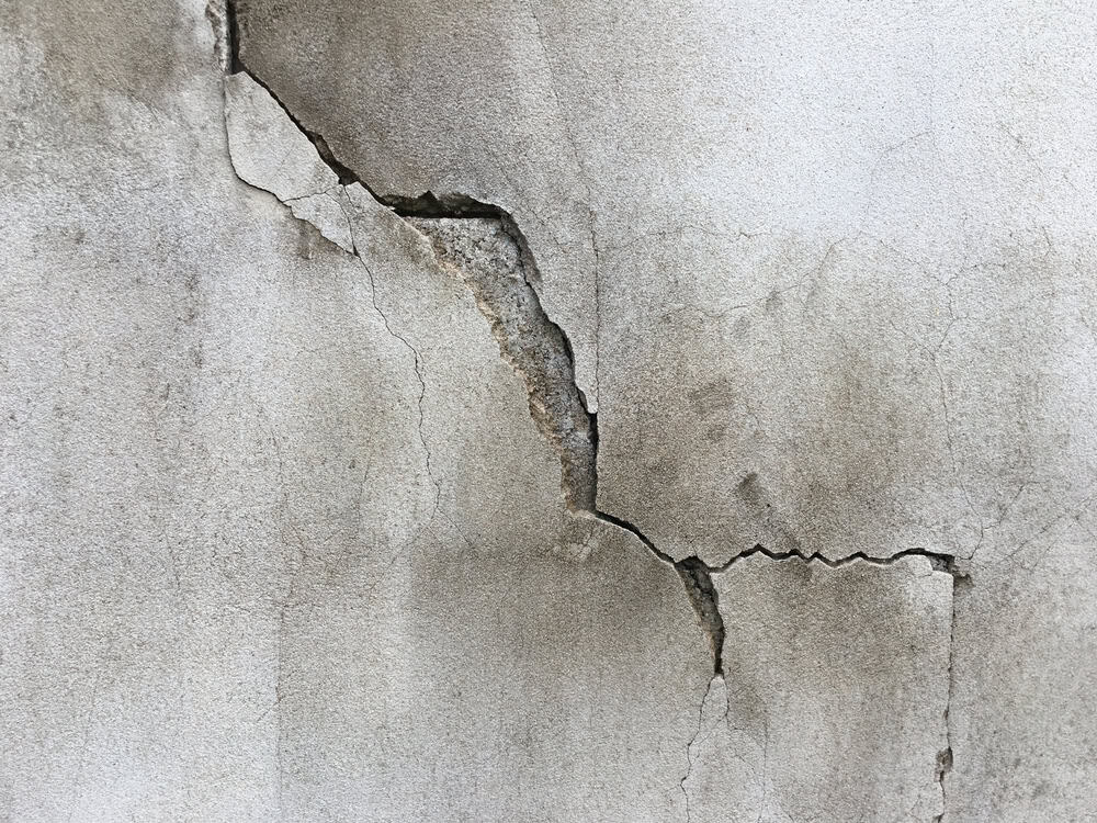 A weathered wall with a prominent crack, revealing the passage of time.