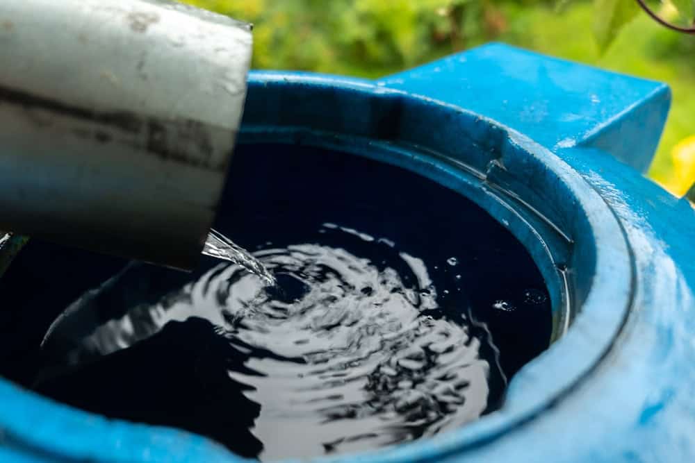 Fresh water flows into a blue barrel.