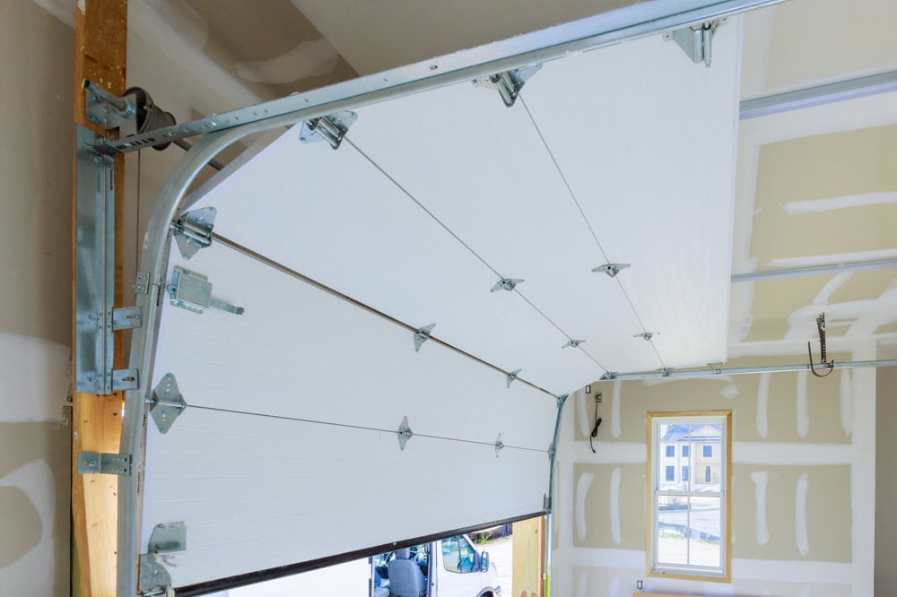 A garage door being installed, revealing a glimpse of the outside world through the window.