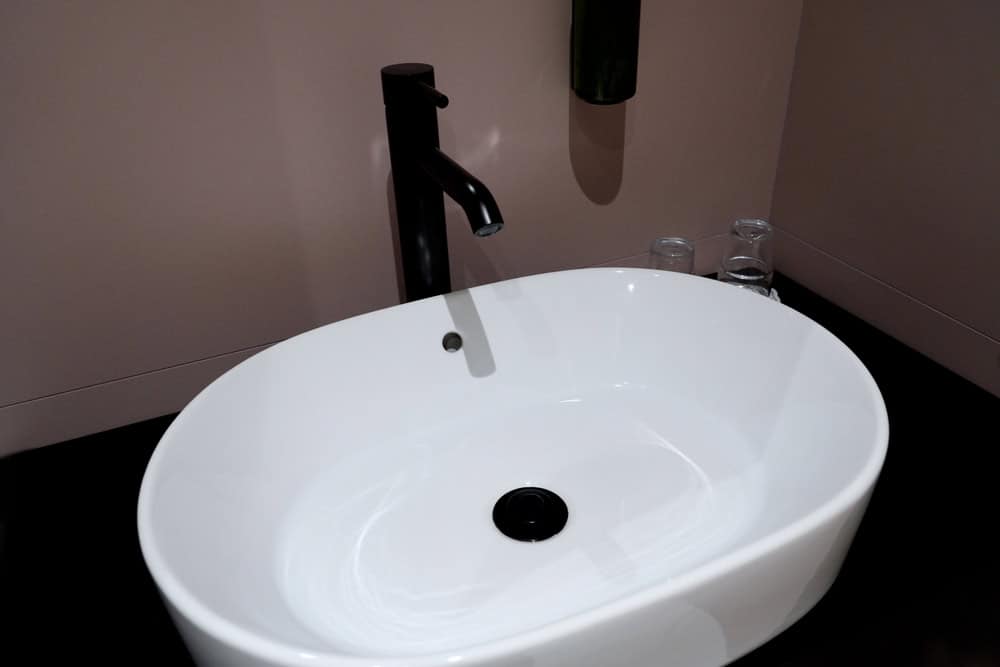 Sleek modern basin with matte black faucet.