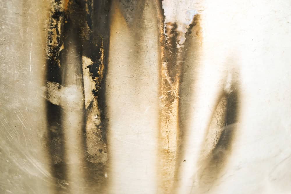 Abstract streaks of light and shadow on a weathered surface, creating a dreamlike interplay of beige, brown and white tones