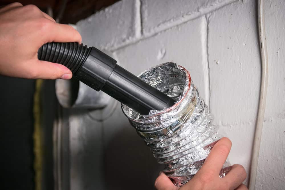 Cleaning a dryer vent with a vacuum to improve efficiency and reduce fire hazards.
