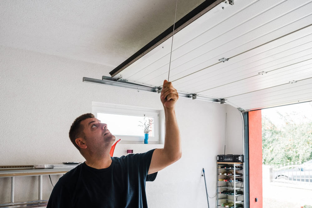 Man manually opens a garage door.