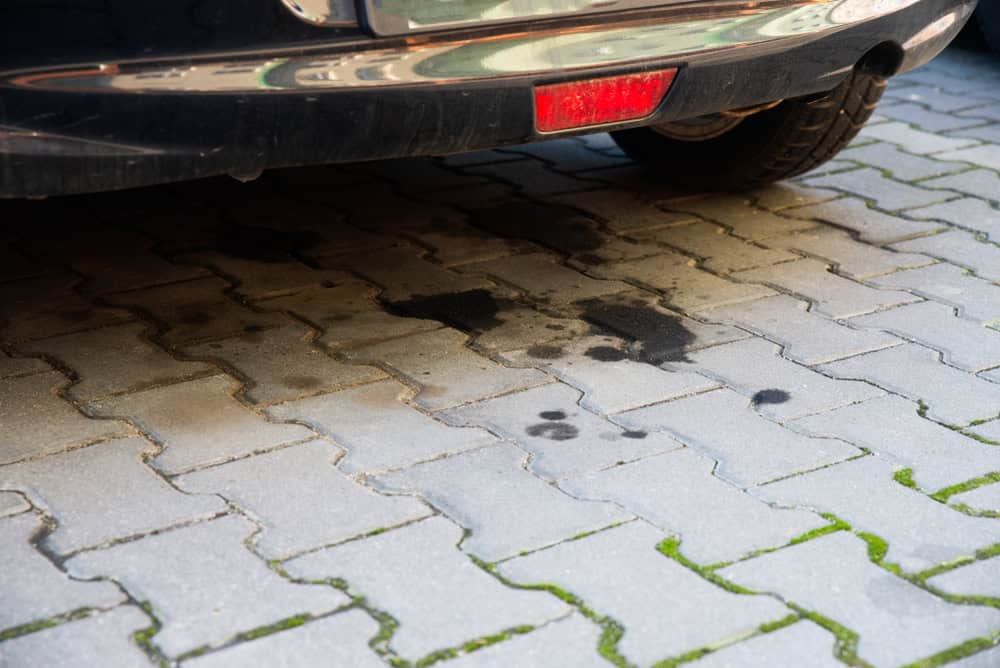 Oil stains on pavement signal a possible leak from the parked car above.