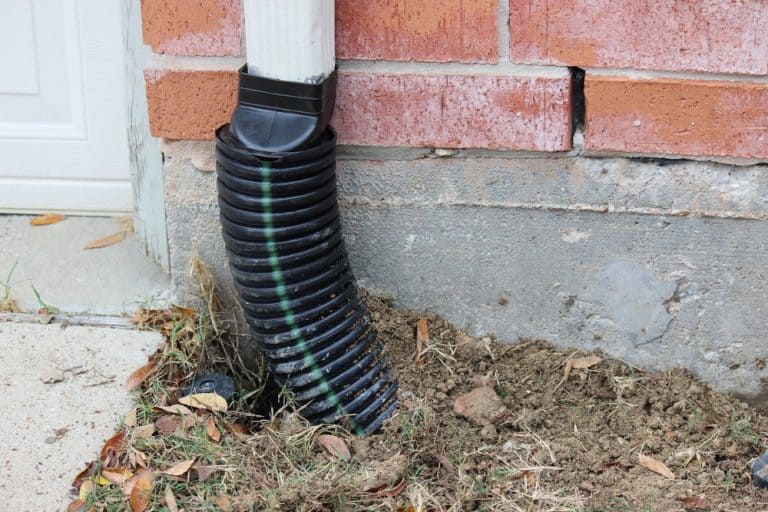A downspout extension bends gracefully to direct rainwater away from the house's foundation.