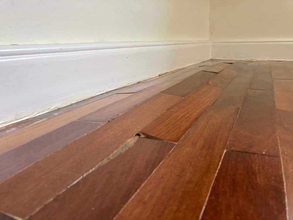 Water damage causing the wooden floor to buckle and warp.