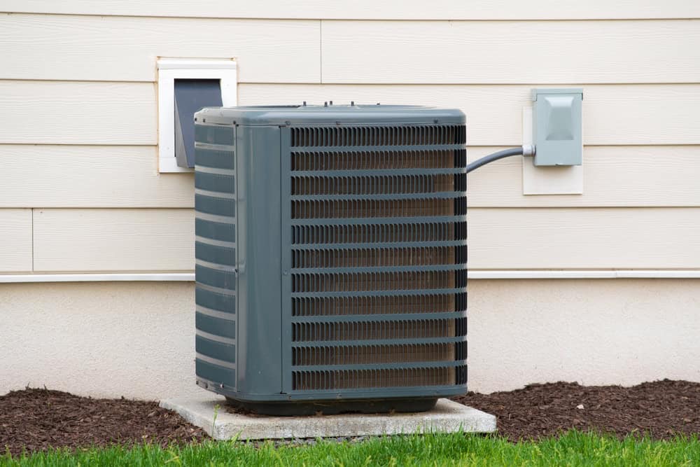 An outdoor air conditioning unit sits quietly against the side of a house, ready to keep things cool.