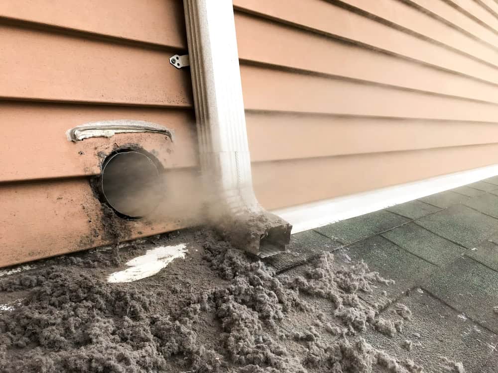 Clogged dryer vent erupts with built-up lint.