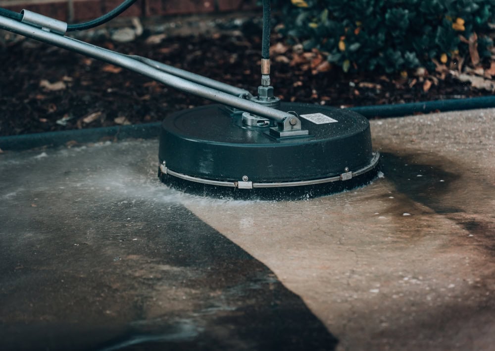 Power washing the driveway to reveal a fresh, clean surface.
