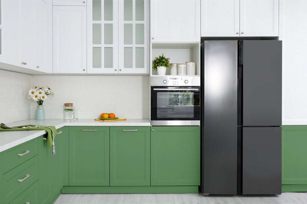 Fresh, modern kitchen with green cabinets and stainless steel appliances.