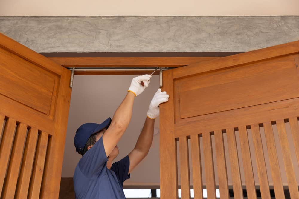 Technician installing a sliding wooden door.