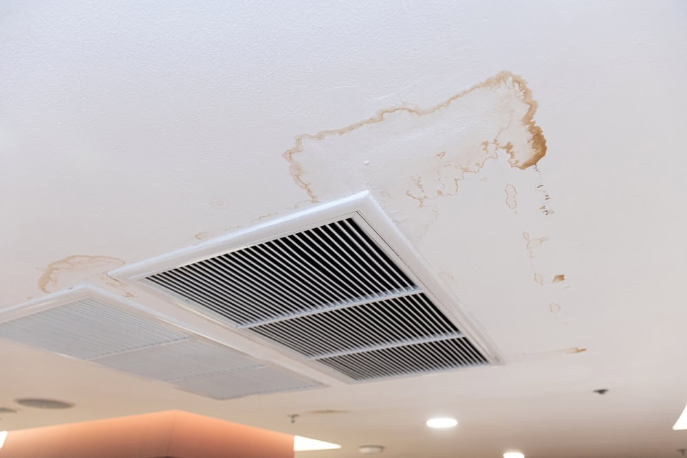 Water damage on the ceiling above an air vent.