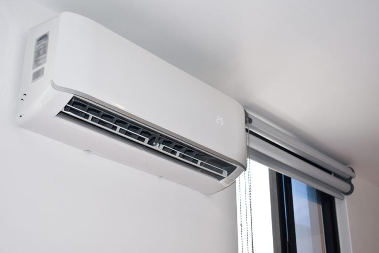 A sleek, modern air conditioner unit installed above a window.