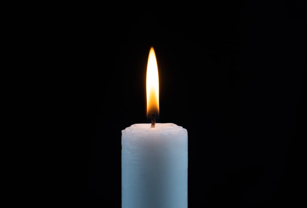 A single candle flame in the darkness.