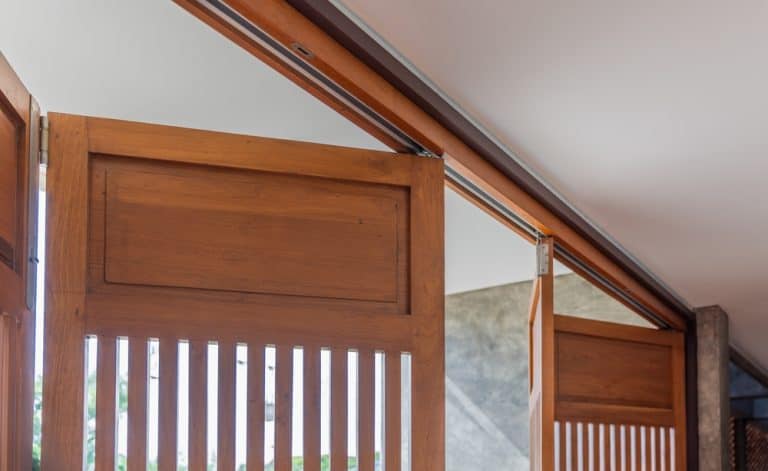 Elegant wooden folding doors open to blend indoor comfort.