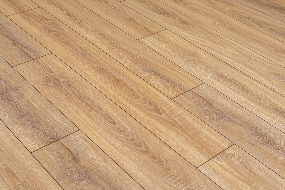 Light oak laminate flooring with prominent wood grain patterns laid in a staggered formation