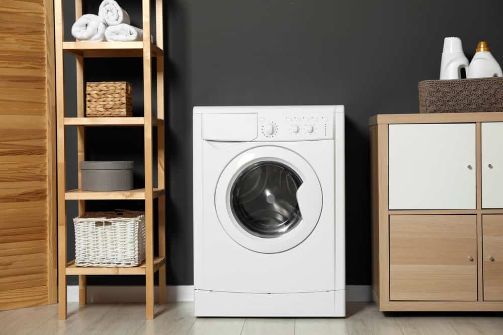 A cozy laundry corner with a sleek white washing machine.