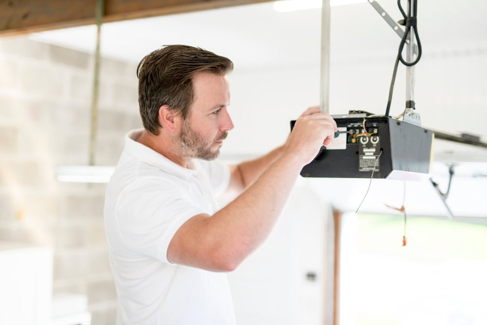 Technician repairs a garage door opener.